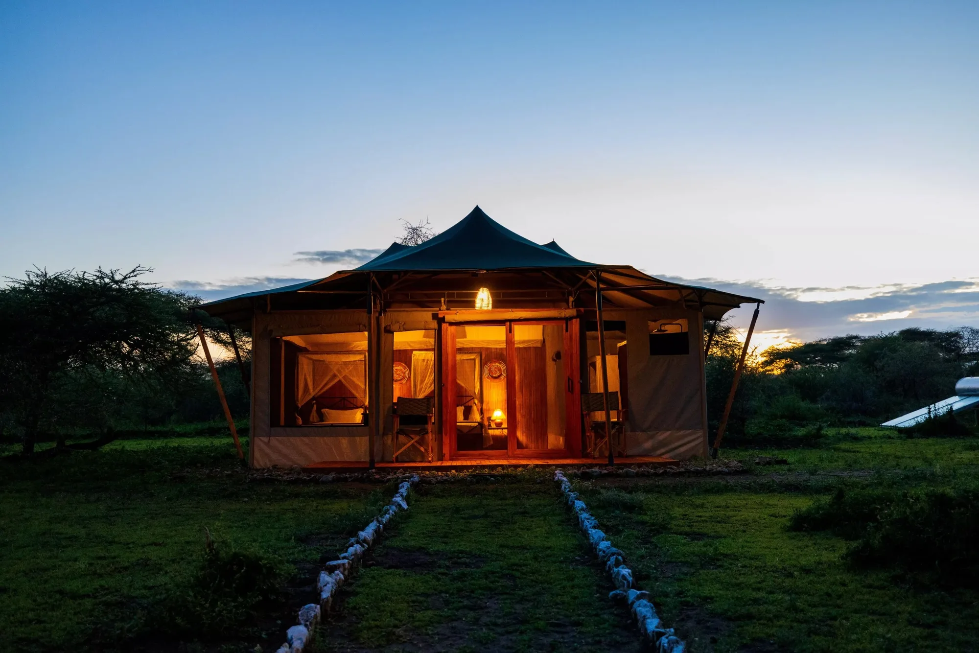 A guest tent lit at dusk
