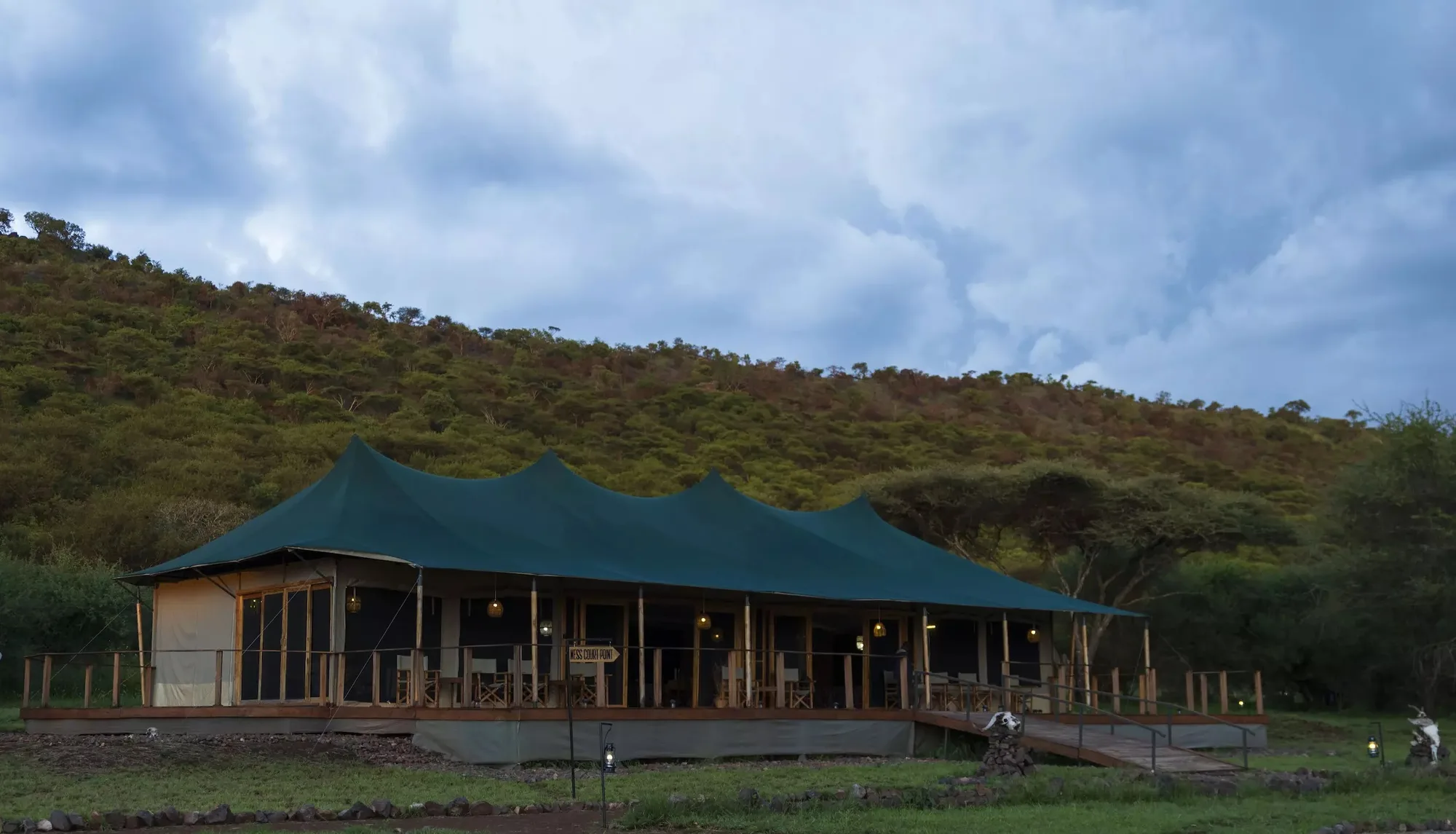 The main tent below a wooded hill