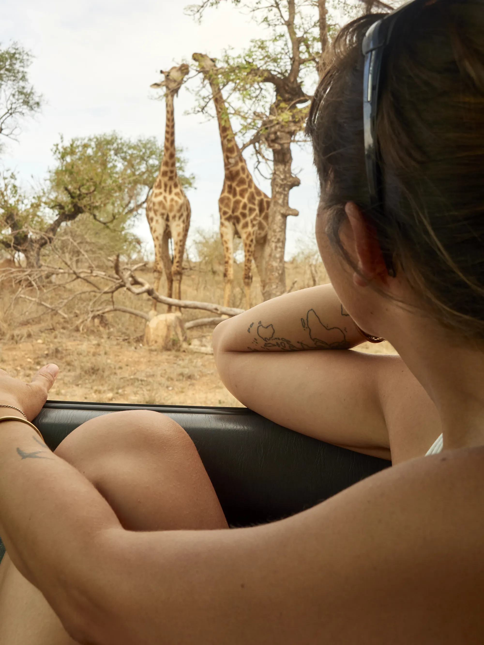 Dressed for the drive — light neutral layers work best in an open safari vehicle.