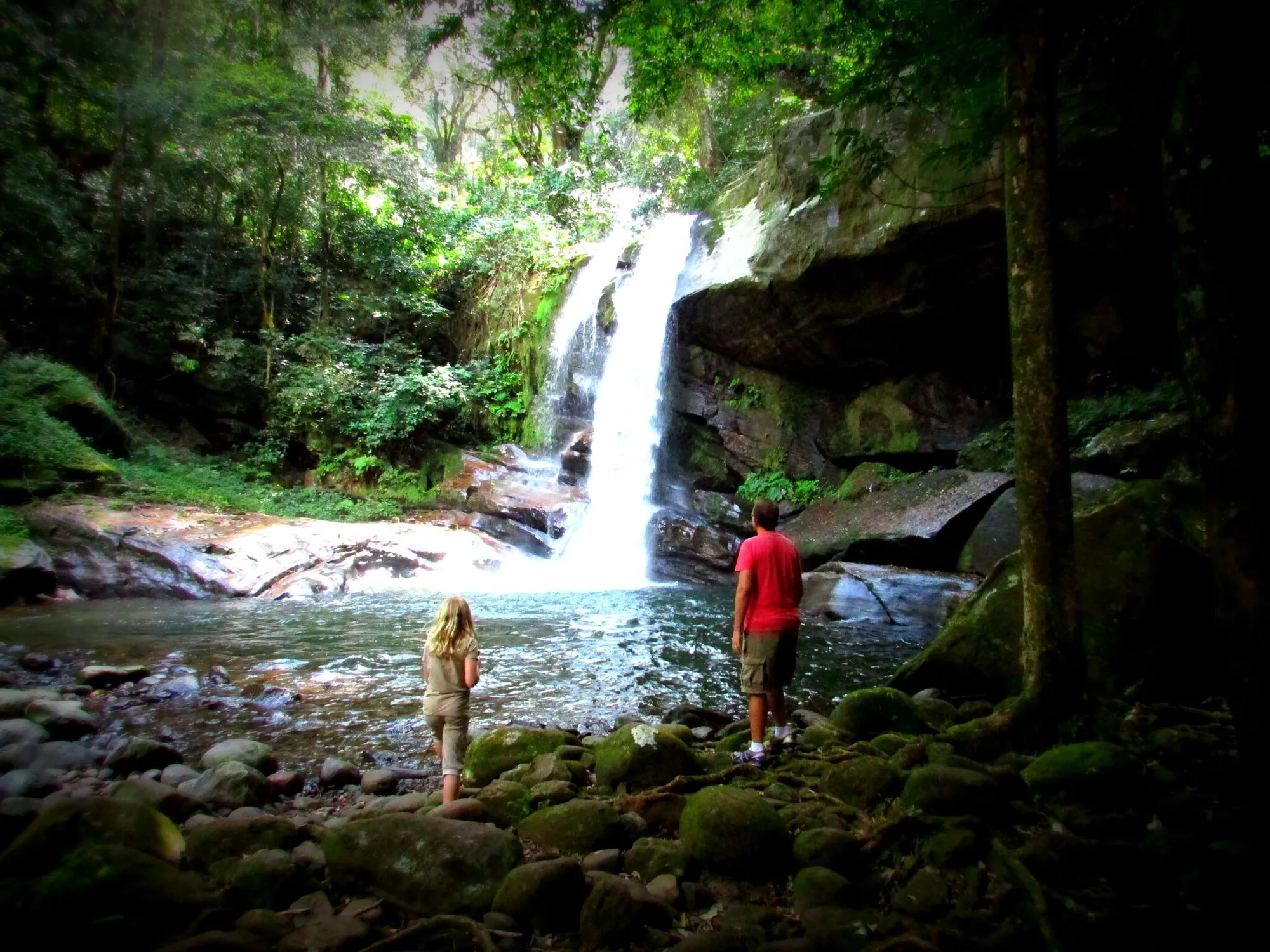 Two hikers at the foot of Sanje Waterfalls in the Udzungwa forest