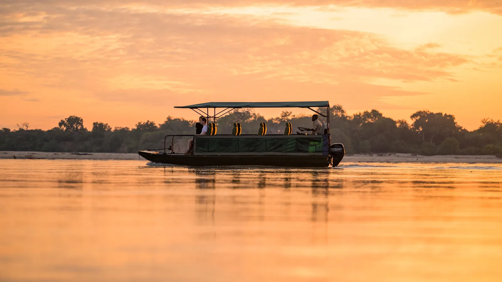 A safari boat on the Rufiji River in Nyerere at sunset